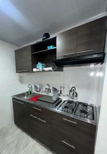 a kitchen with a stove and a sink in it at Apartamento Vacacional Familiar en Girardot, piscinas, Jacuzis, parqueadero privado in Girardot