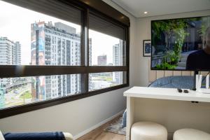 La salle de bains est pourvue d'une fenêtre offrant une vue sur la ville. dans l'établissement Loft 907 Parque Una - Aurora, à Pelotas
