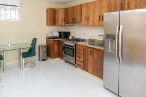 a kitchen with wooden cabinets and a stainless steel refrigerator at La Isla Royal - Pool Side Suite in Miches +3 photos