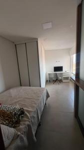a bedroom with a bed and a flat screen tv at Apartamento Completo com 2 Camas in Euclides da Cunha