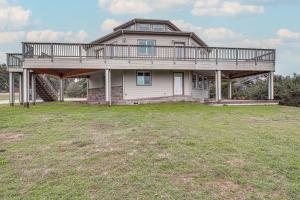 a large house with a deck on top of a yard at Groups Welcome! Ocean-View Escape in Gold Beach in Gold Beach