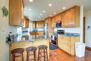 a kitchen with wooden cabinets and bar stools at Groups Welcome! Ocean-View Escape in Gold Beach in Gold Beach