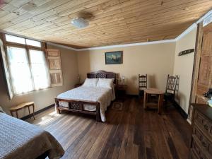 a bedroom with two beds and a wooden ceiling at Hostal Casa Rosada, Valle del Elqui in Rivadavia +21 photos