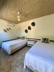 a bedroom with two beds and a ceiling at Pousada Villa do Sol Taiba in Taíba +82 photos
