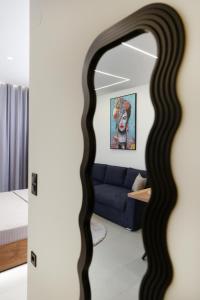 a living room with a blue couch and a mirror at Aristotelous rooms Nikol in Thessaloniki +17 photos