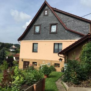a house with a black roof and a yard at Ferienwohnung Mönch in Christes