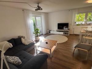 OberteuringenBusiness & Monteur Apartment - Modern Style & Comfort - Bodensee-Oberschwaben的客厅里有一张沙发和一张桌子。