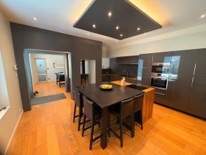 a kitchen with a black table and a dining room at Charmante maison avec piscine in Turquant