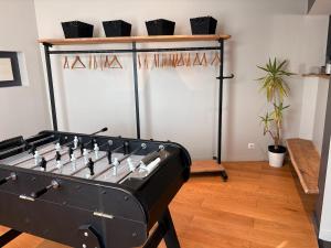 a room with a foosball table in a room at Charmante maison avec piscine in Turquant