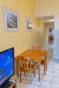 a dining room with a wooden table and a tv at BBQ ok Ground Floor Duplex 1-2 block to Beach in South Padre Island +70 photos