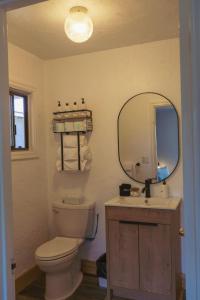 a bathroom with a toilet and a sink and a mirror at The Spinn in Manzanita