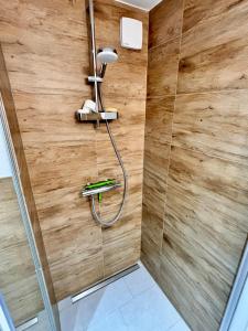 y baño con ducha y pared de madera. en Unique apartment near Frankfurt, en Neu Isenburg