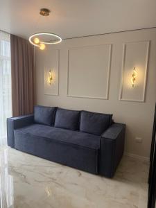 a blue couch sitting in a living room at Apartment Uman in Umanʼ