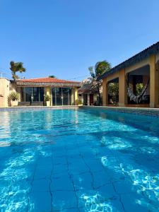 a swimming pool in front of a house at Pousada Villa do Sol Taiba in Taíba