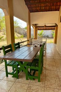 a wooden table and chairs on a patio at Pousada Villa do Sol Taiba in Taíba