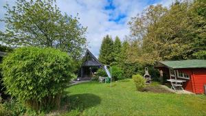 a garden with a small house and a shed at Chalet in Freilingen Blankenheim mit Seenähe mitten in der Natur in Blankenheim