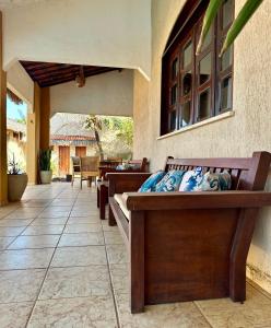 a porch with a wooden bench on a patio at Pousada Villa do Sol Taiba in Taíba