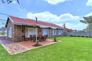 una casa de ladrillo con una mesa y sillas en un patio en Aviator's Nest, en Kempton Park