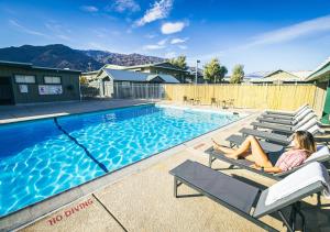 a woman laying on a chair next to a swimming pool at Stovepipe Wells Village in Death Valley