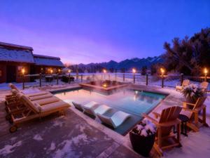 a swimming pool with lounge chairs and a resort at Ninepipes Lodge in Polson