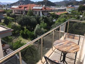 einen Balkon mit einem Holztisch und Stadtblick in der Unterkunft Kaya Home Ortaca Günlük Apart Daire in Ortaca