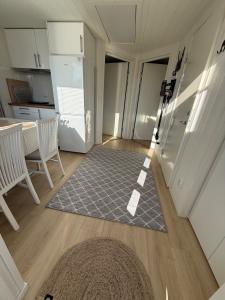a kitchen with a table and chairs and a rug at Jönåker Cottage & Sauna in Jönåker