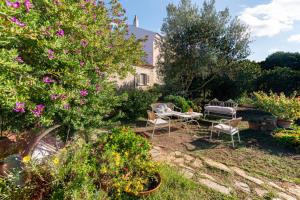 a garden with a table and chairs and flowers at Casa Lilliosa in San Pasquale
