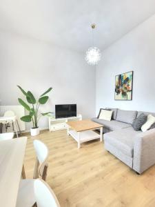 una sala de estar con un sofá y una mesa en Ursus Premium Apartments, en Varsovia