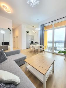 una sala de estar con un sofá y una mesa en Ursus Premium Apartments, en Varsovia