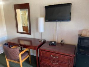 een kamer met een bureau, een televisie en een dressoir bij Paramount Motel Pocono in East Stroudsburg