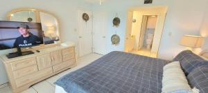 a bedroom with a bed and a flat screen tv at Resort like super heated pool & direct beach front in South Padre Island