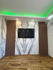 a room with a tv on a wall at Apartmani AX in Pančevo