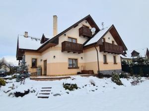 a house with snow on the ground in front of it at Villa Ďurčík in Veľká Lomnica