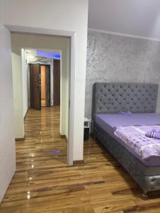 ein Schlafzimmer mit einem Bett und einem Holzboden in der Unterkunft Apartmani AX in Pančevo