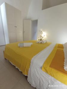 a bedroom with a large bed with a yellow blanket at ALMAREDo in Bisceglie