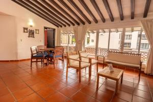 a living room with a table and chairs and windows at La Iguana Vallarta LGBT ADULTS ONLY - Romantic Zone - Party Clubbing Street in Puerto Vallarta