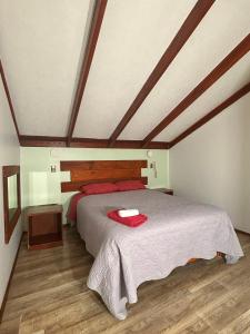 a bedroom with a bed with a red towel on it at Hotel California in Temuco