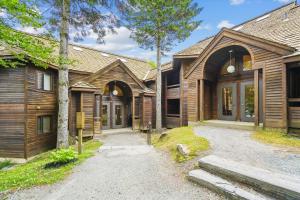 una casa de madera con un camino delante en Wonderful One bedroom condo located in Highridge Condominiums J6, en Killington