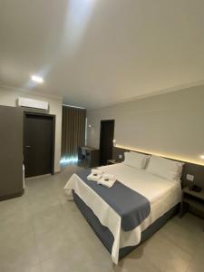 Ένα ή περισσότερα κρεβάτια σε δωμάτιο στο Uberlândia Suítes