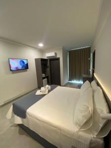 Ένα ή περισσότερα κρεβάτια σε δωμάτιο στο Uberlândia Suítes