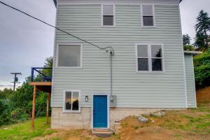 a house with a blue door on the side of it at 4 Blocks to Riverwalk Updated Astoria Studio in Tongue Point Village