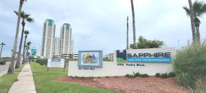 a sign at the entrance to a resort with palm trees at Luxury 17th Floor Beachfront Stunning Views in South Padre Island +154 photos