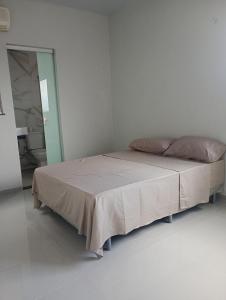 una camera da letto con un letto in una stanza bianca di Your New Home a Belém