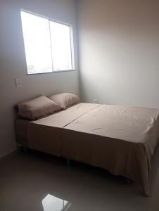 un letto in una stanza bianca con una finestra di Your New Home a Belém