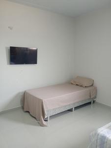 Posto letto in camera con parete bianca di Your New Home a Belém