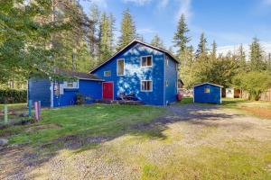 une maison bleue avec une porte rouge dans une cour dans l'établissement Fire Pit and Mountain Views Outdoorsy PNW Escape, à Gold Bar