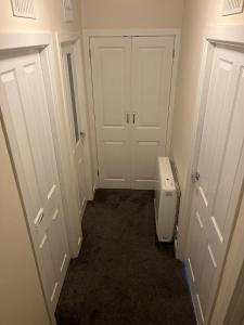 オーバンにあるFlat in Oban town centreの白いドアとトイレ付きの廊下