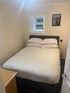 オーバンにあるFlat in Oban town centreの部屋にある白いシーツと枕が置かれたベッド