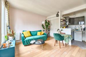 a living room with a green couch and a table at Basilica of the Sacred Heart - Heart of Montmartre in Paris