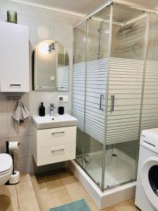 a bathroom with a glass shower and a sink at Duży apartament z kuchnią i łazienką in Namysłów +10 photos